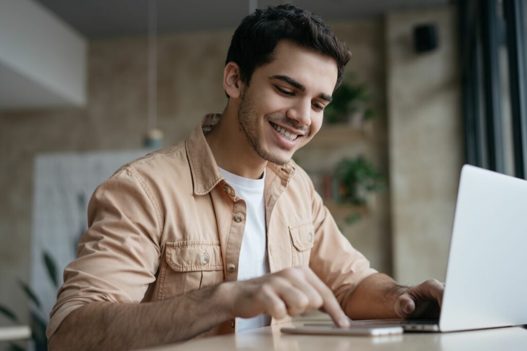 Santander Tagesgeld: Mann am Laptop mit Handy