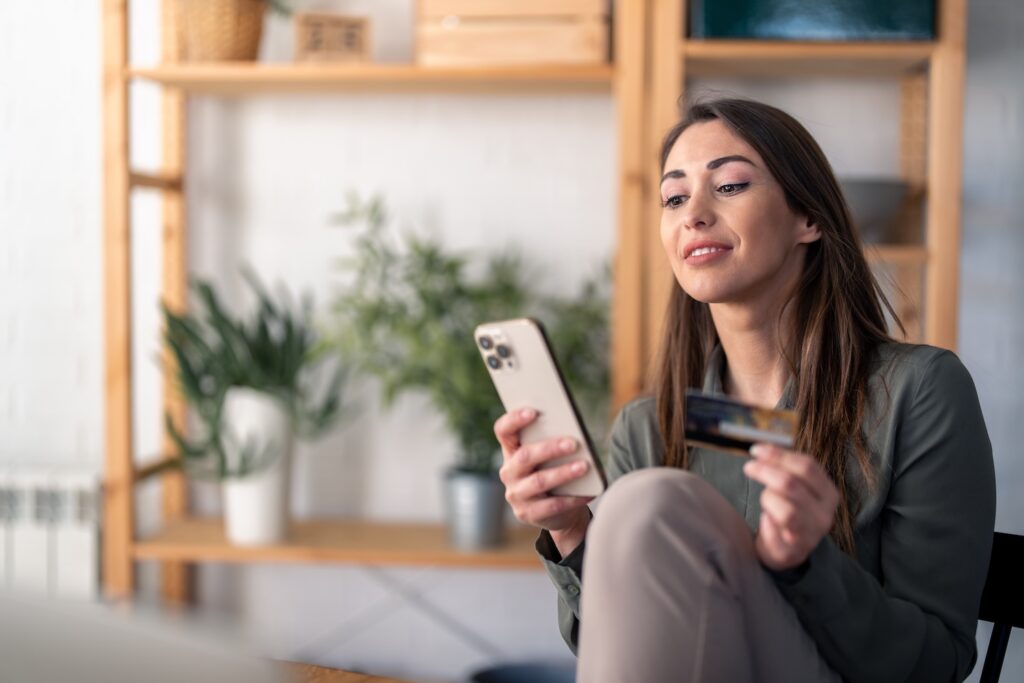 Online Banking: Frau am Handy mit Kreditkarte